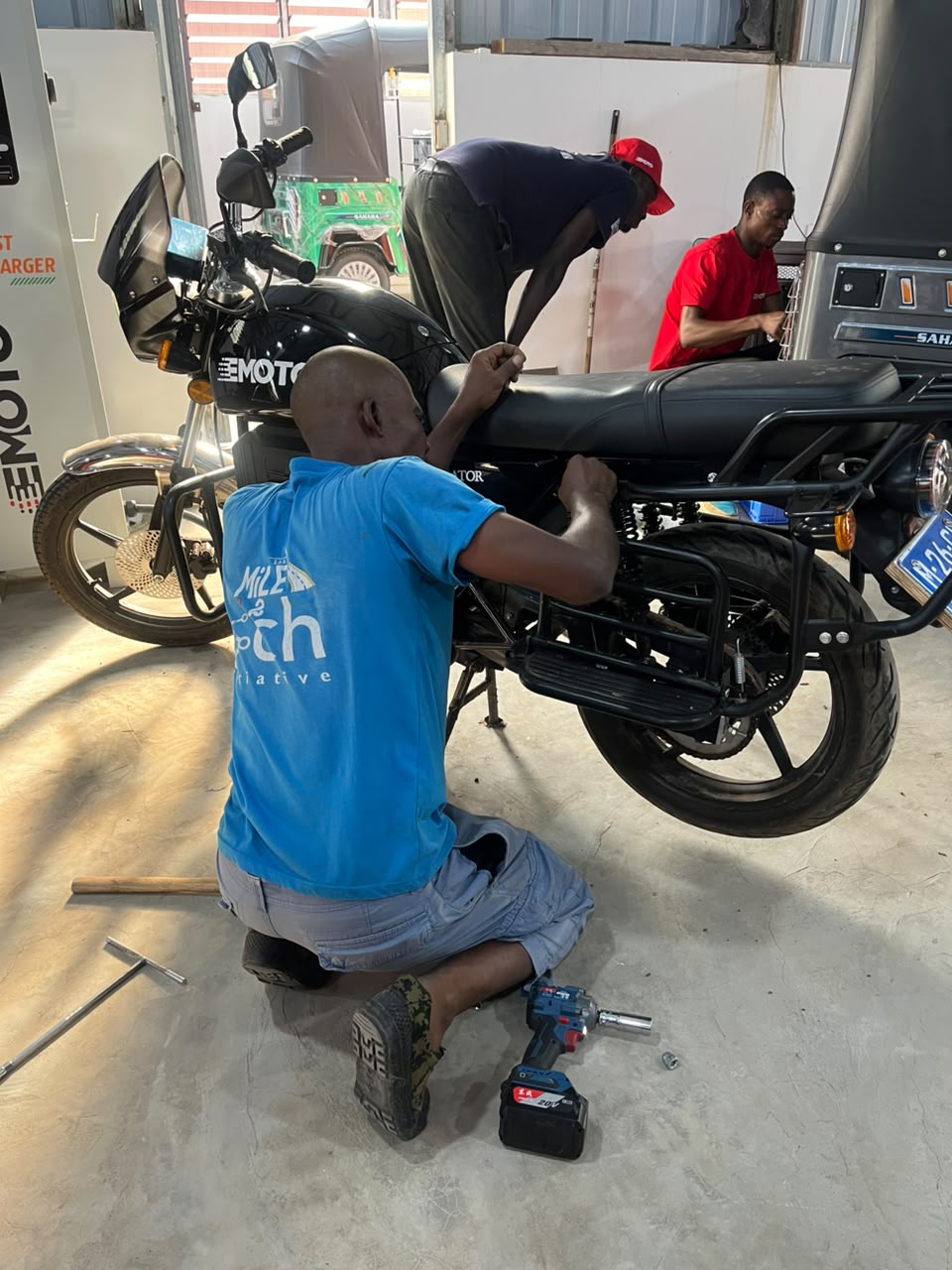 EMoto technician performing routine maintenance on an electric motorcycle